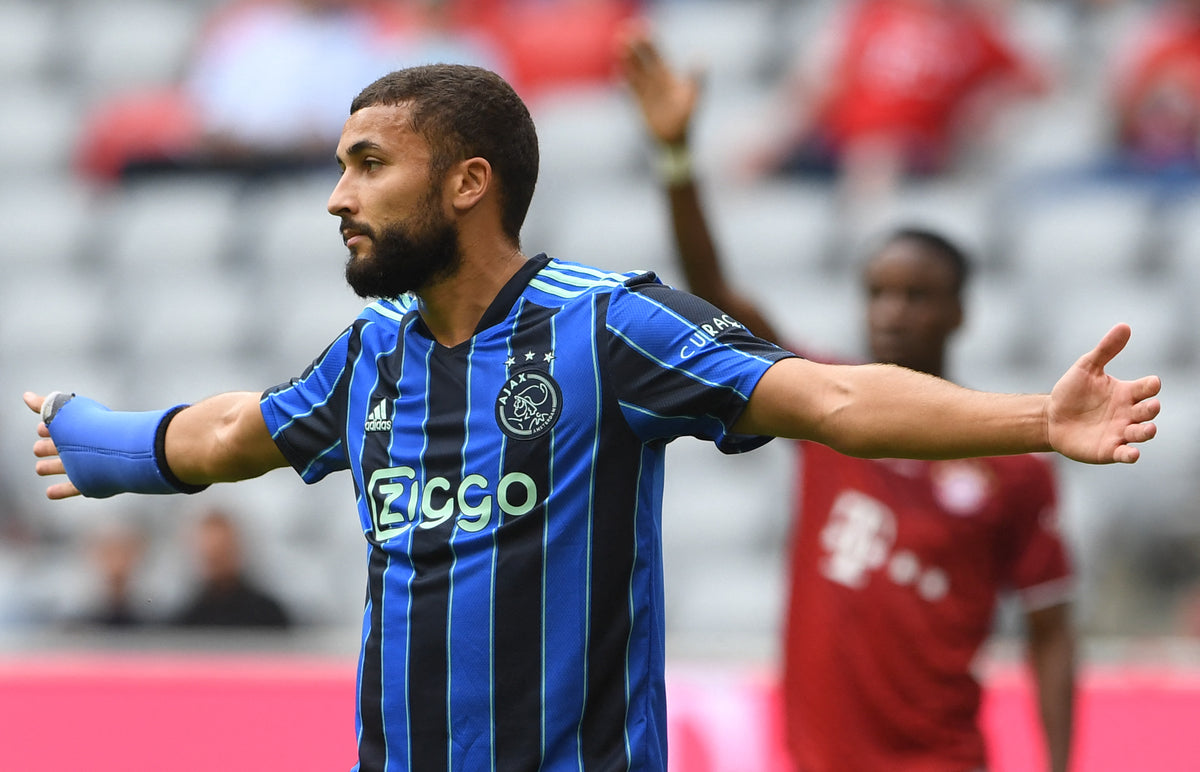 Zakaria Labyad spreidt zijn armen in het blauw-zwarte uitshirt van Ajax