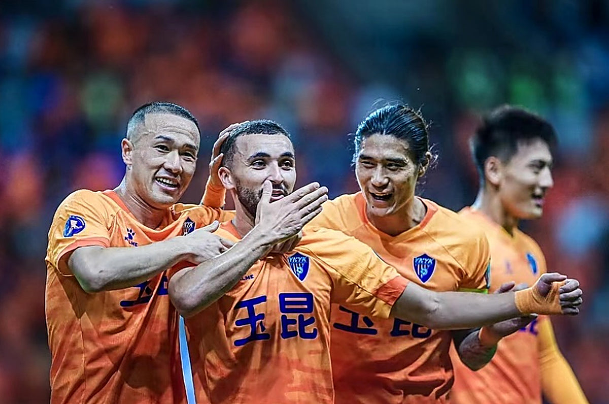 Zakaria Labyad feiert ein Tor mit Teamkollegen im orangefarbenen Trikot von Yunnan Yukun